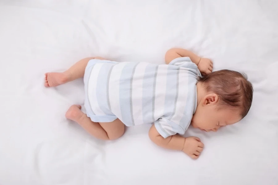 Baby in striped white and blue cotton onesie sleeping