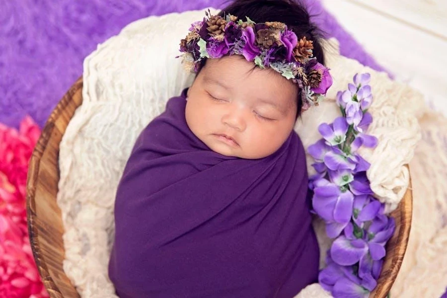 Baby placed in a basket wrapped in purple swaddle