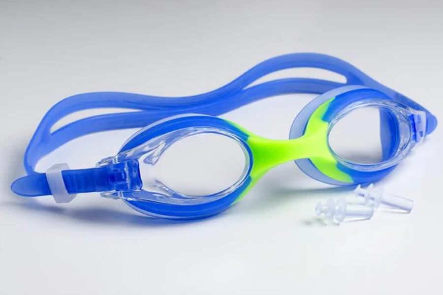Blue glasses and earplugs in a swimsuit on a white background