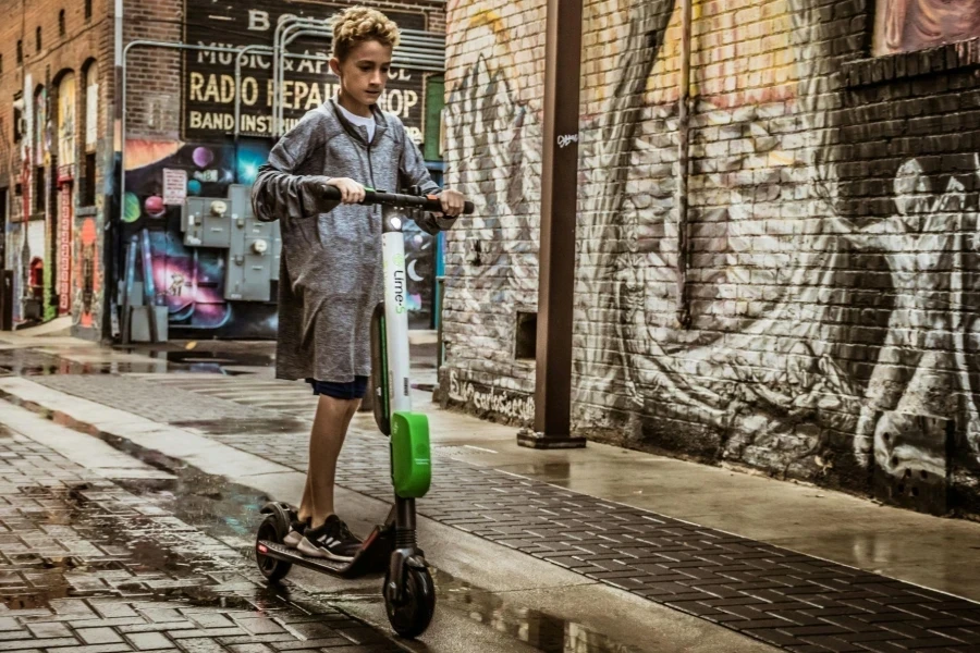 Boy Standing on Black and White Kick Scooter