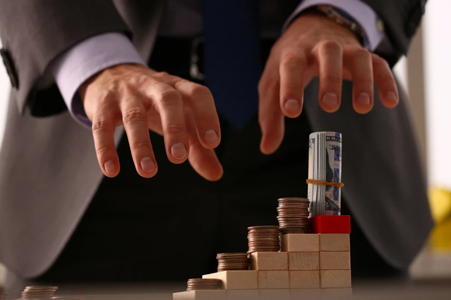 Businessman reaching for a pile of money