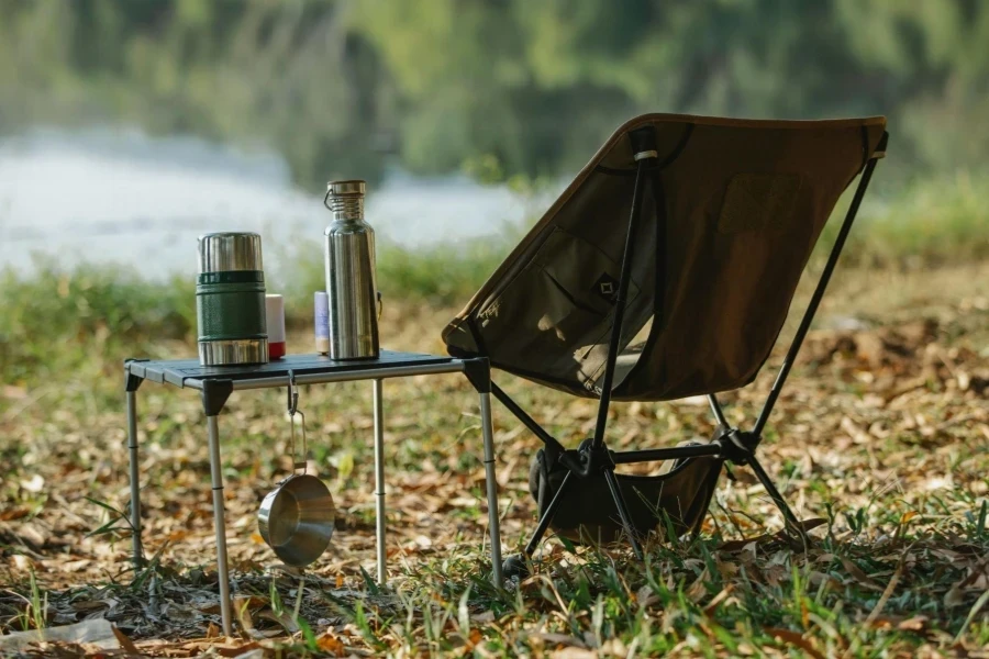 Camping chair near table on river shore