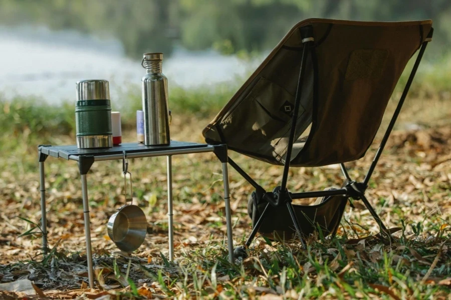 Camping chair near table on river shore