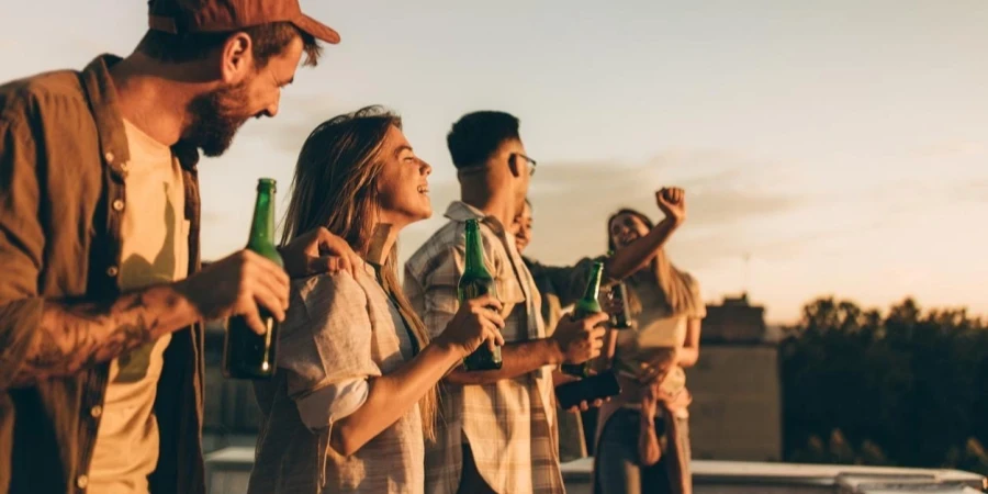 Cheerful friends having fun while drinking beer on a roof