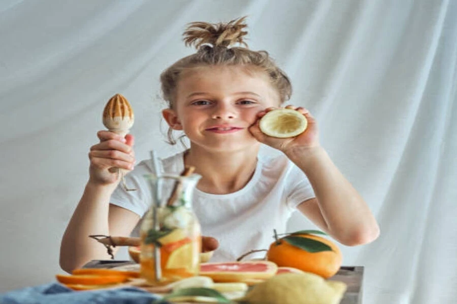 Child holding wooden manual lemon squeezer with lemon