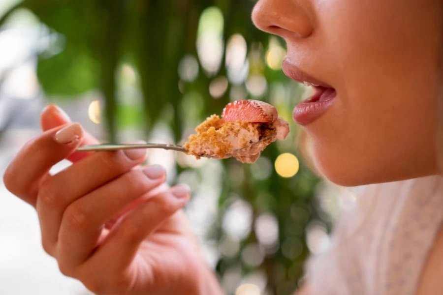 Close-up of girl eating strawberry dessert tiramisu with spoon