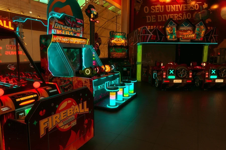 Colorful neon-lit arcade with various game machines including Fireball and Dinosaur Era