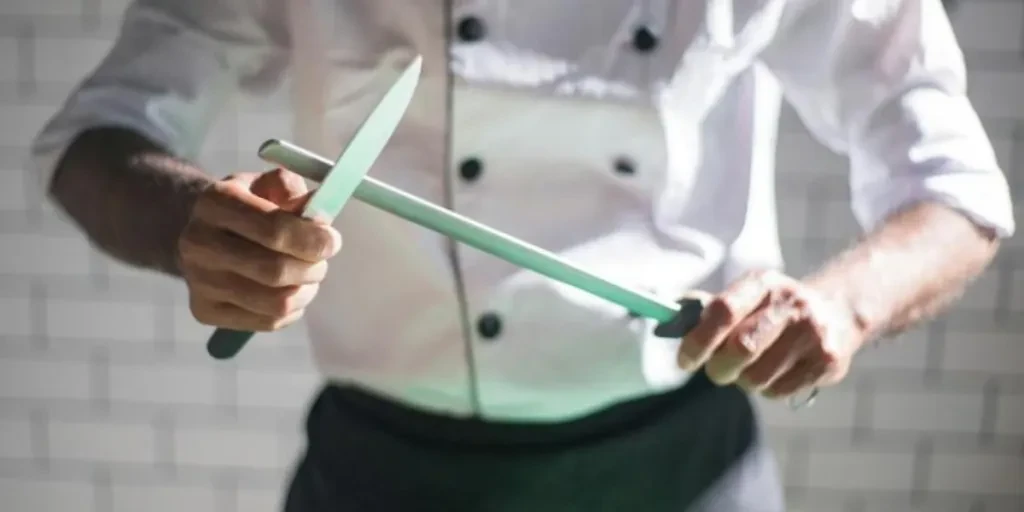 Cook sharpening knife on honing rod