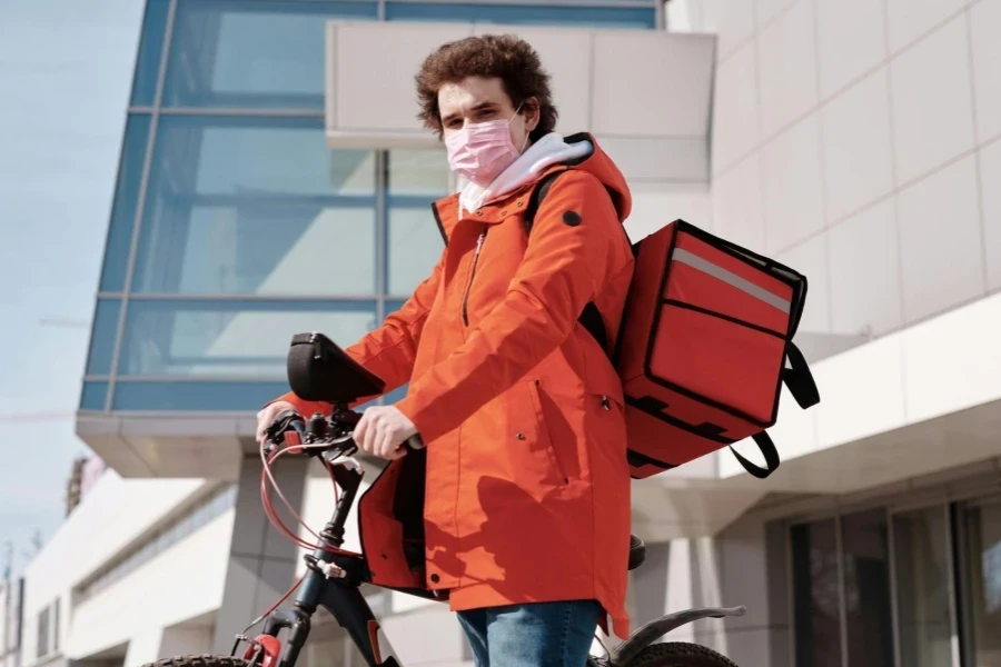 Delivery Man Wearing a Face Mask and Riding a Bicycle
