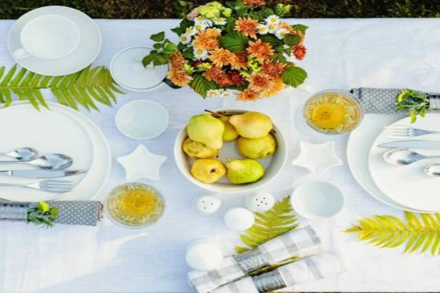 Dinner plates with white cloth and summery decorations