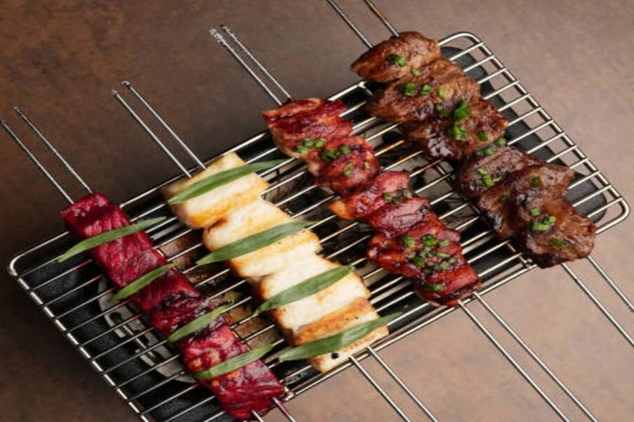 Double-prong skewer sets with meat sitting on grill grates