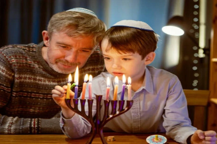 Family lighting colorful menorah candles