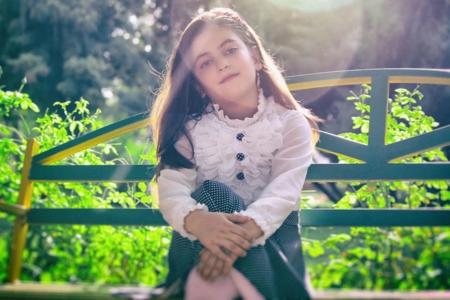 Girl Sitting on Bench Near Plants