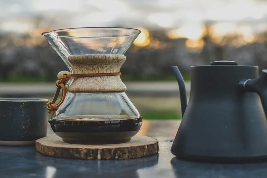 Glass coffee carafe on outdoor table at sunrise