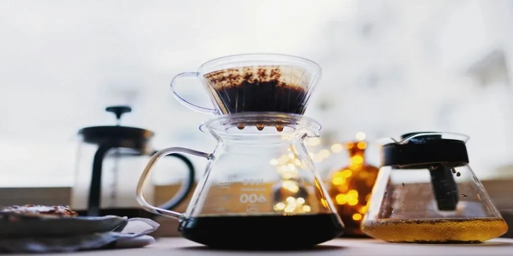 Glass coffee carafe with coffee grounds and brewing cone