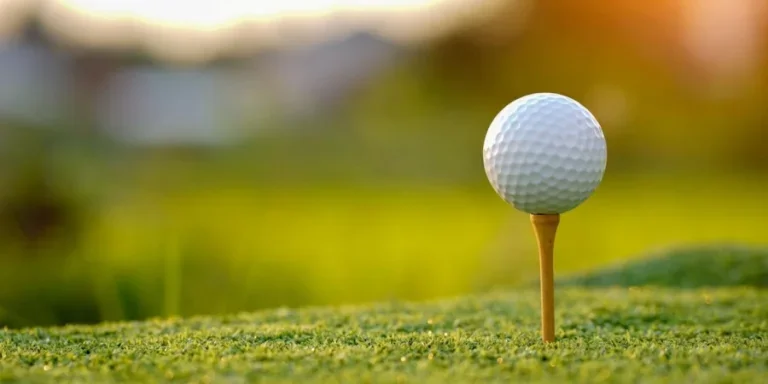 Мяч для гольфа на ти на поле для гольфа