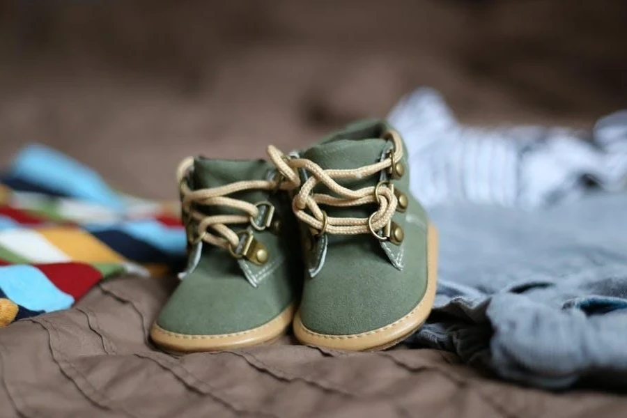 Green and beige baby booties on babies’ clothing