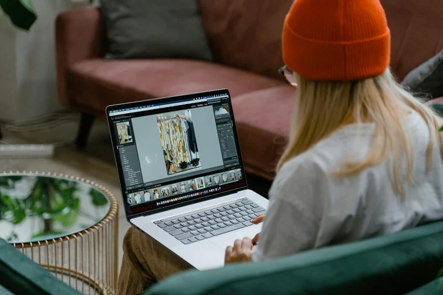 Lady with blonde hair editing images on a laptop