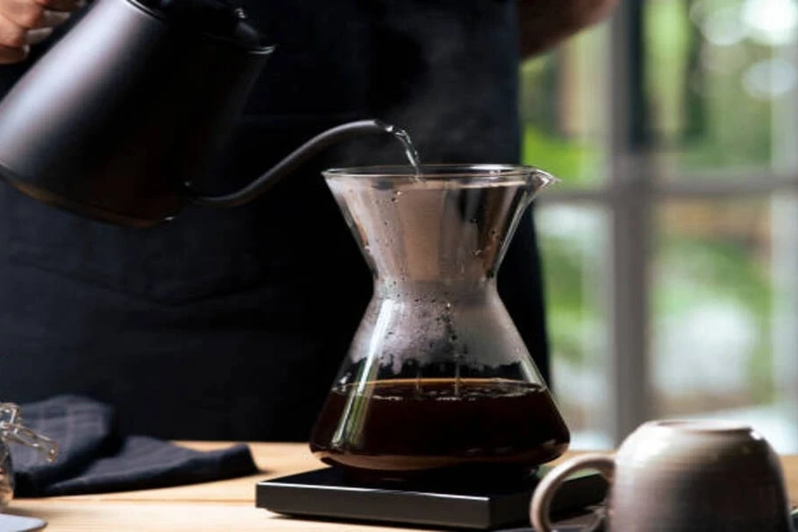 Large traditional glass coffee carafe with hot water poured in