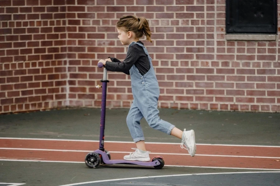 Little girl riding scooter on stadium