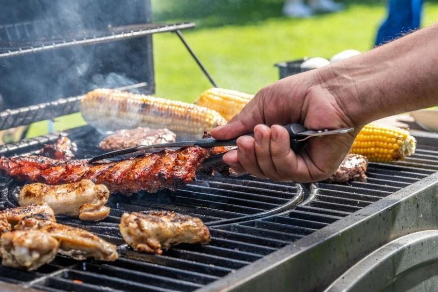 Man Using Tongs Take Meat Off Grill