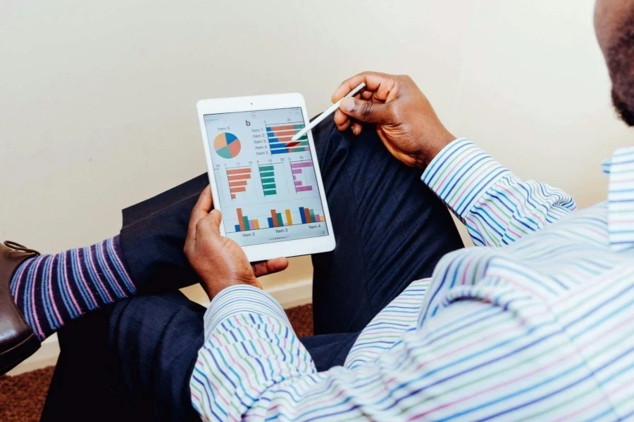 Man Wearing White and Blue Pinstriped Dress Shirt Holding White Ipad