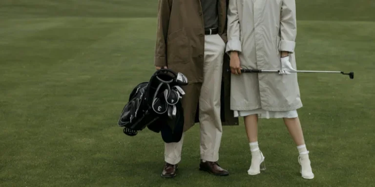 Man and Woman in Coats Standing on Lawn at Golf Course