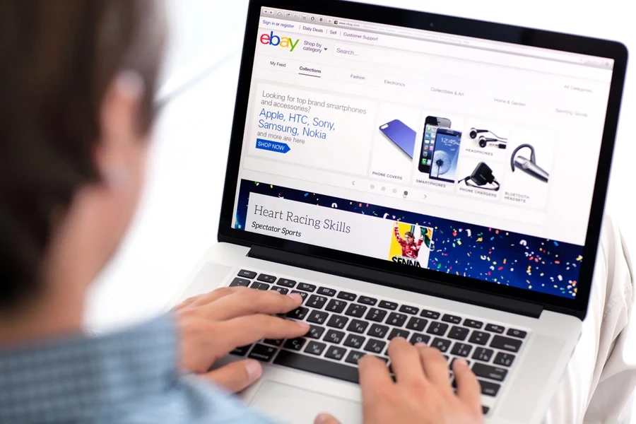 Man checking an eBay listing on a MacBook