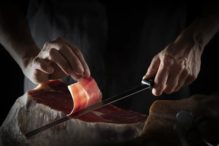 Man cutting a thin slice of meat