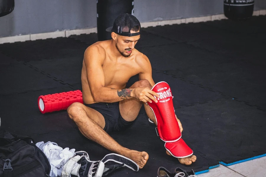 Man gearing up with protective pads for martial arts