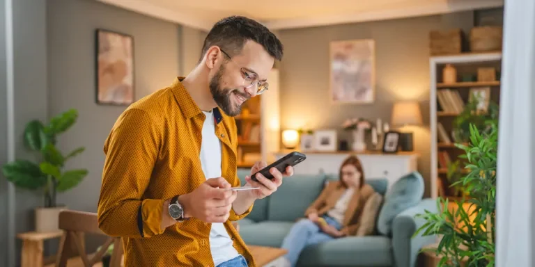Man holding a credit card for an online purchase