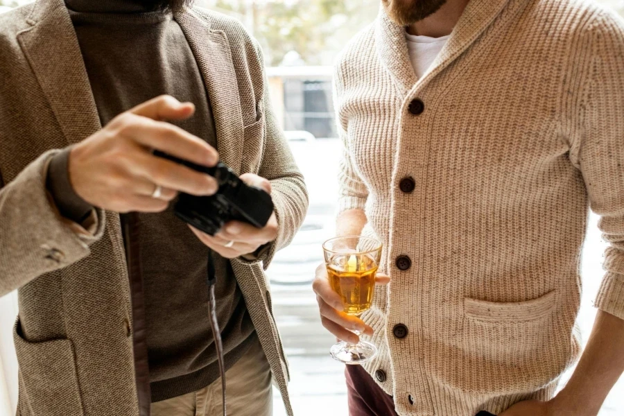 Man in Brown Sweater Holding Black Dslr Camera