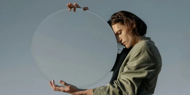 Hombre con chaqueta verde sosteniendo una bola de cristal transparente