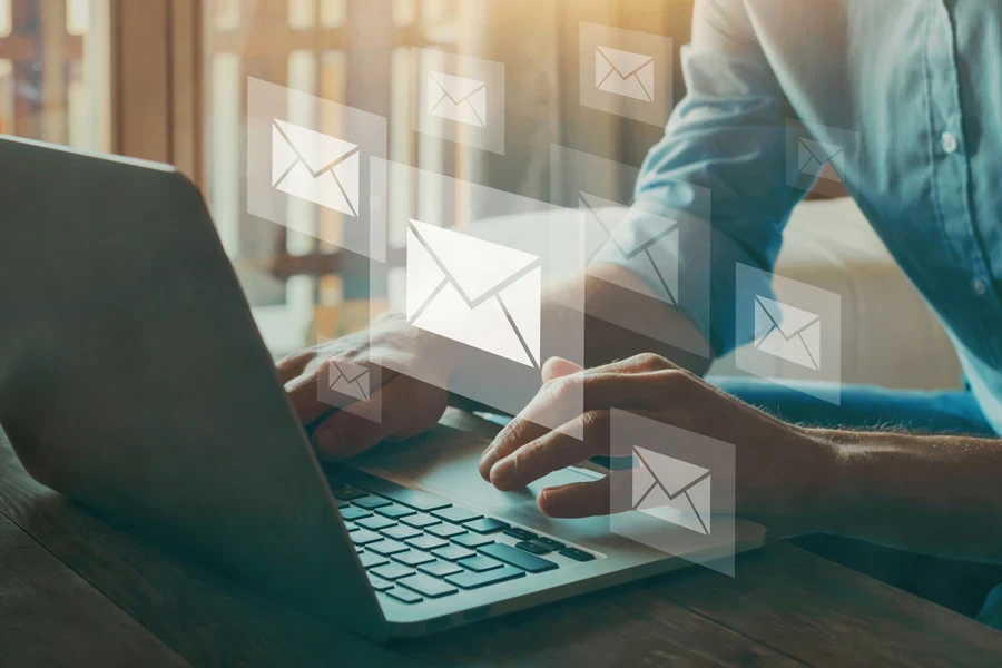 Man making multiple emails on his laptop