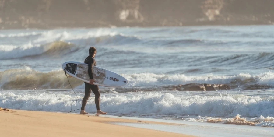 Man preparing for surfing in wavy ocean