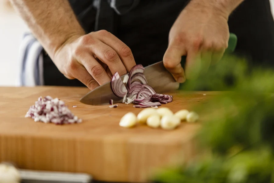 Man slicing onions with a chef’s knife