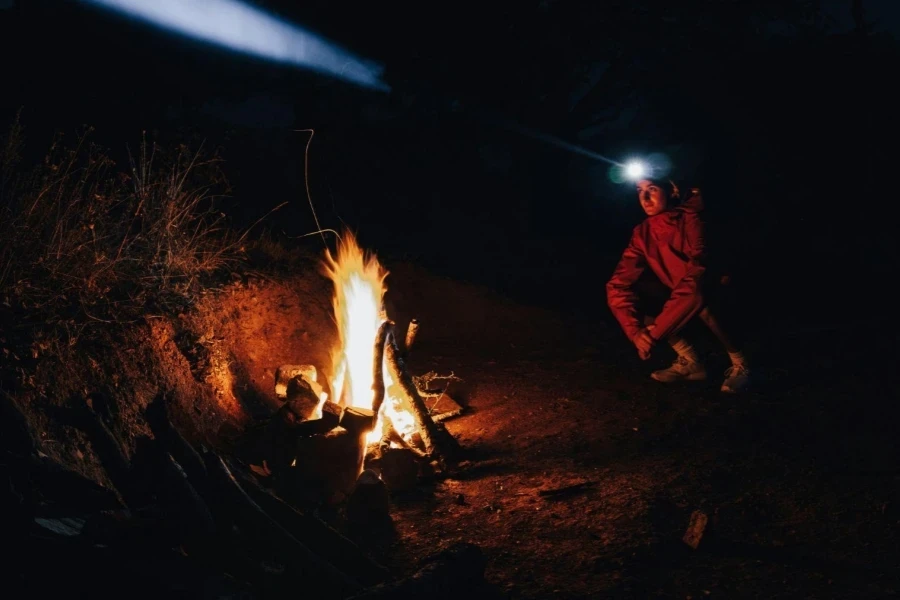 Man with a Flashlight on His Forehead by the Campfire