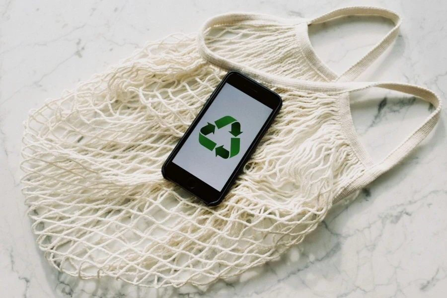 Mobile Phone with Green Recycling Sign and Mesh Bag