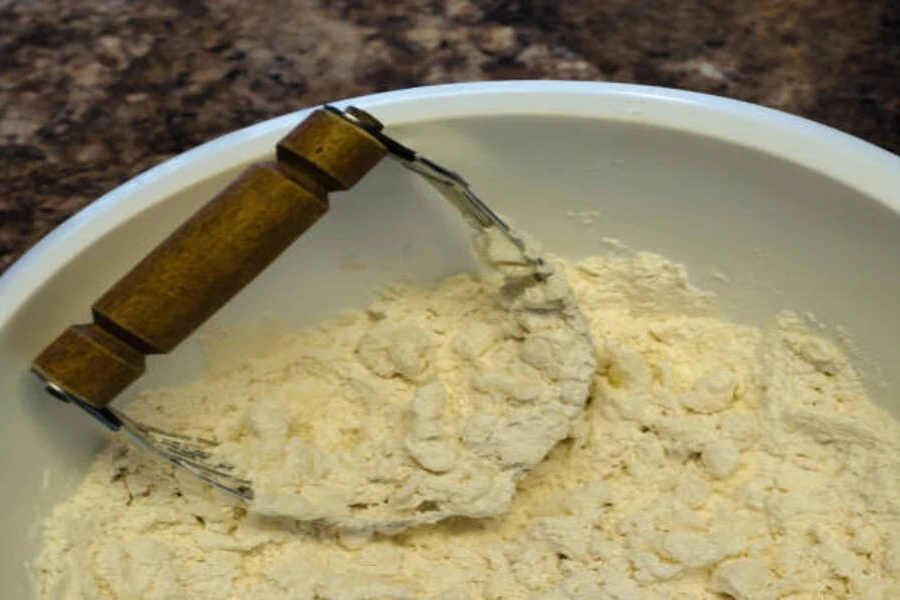 Pastry blender with wooden handle inside mixing bowl