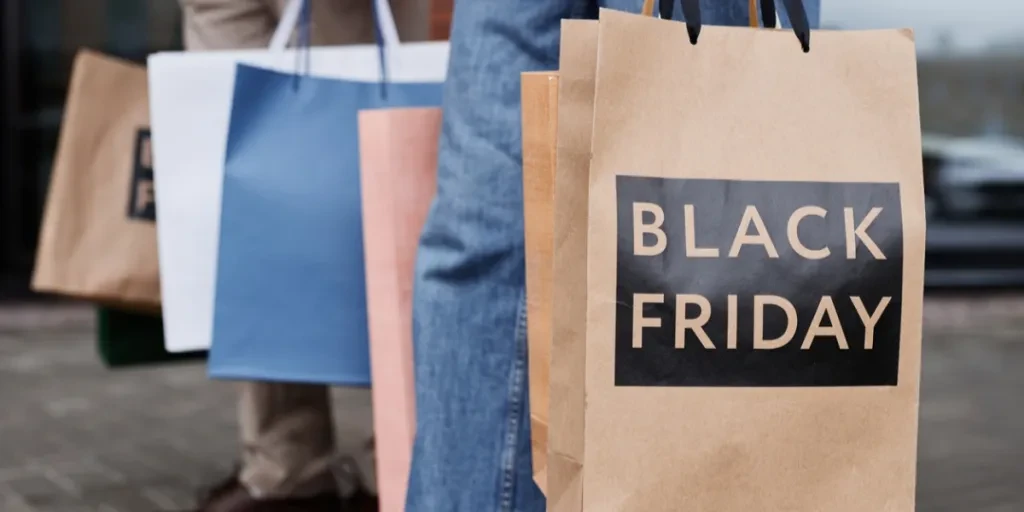 People carry shopping bags labeled “Black Friday