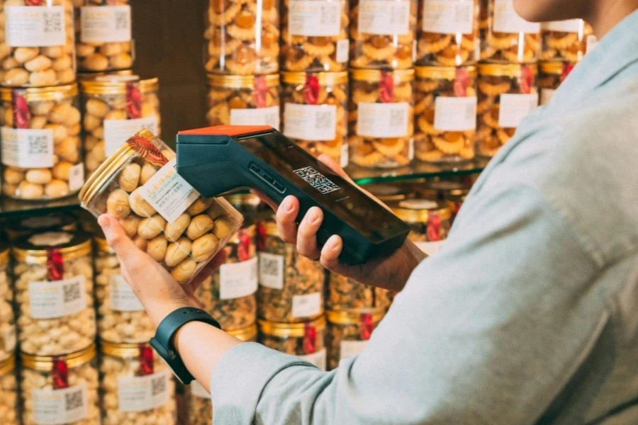 Person Scanning QR Code on Jar of Pickles
