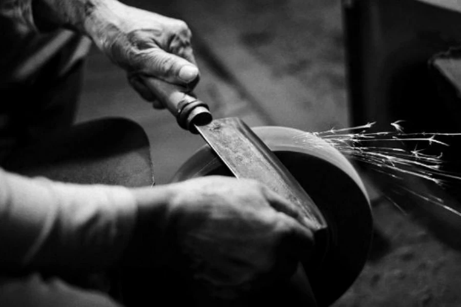 Person sharpening cleaver on wheel