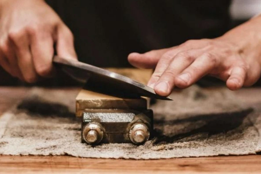 Person sharpening knife on whetstone