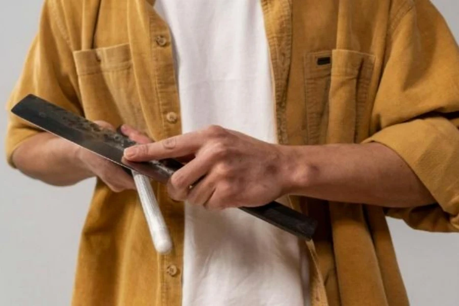 Person using a steel knife sharpening rod
