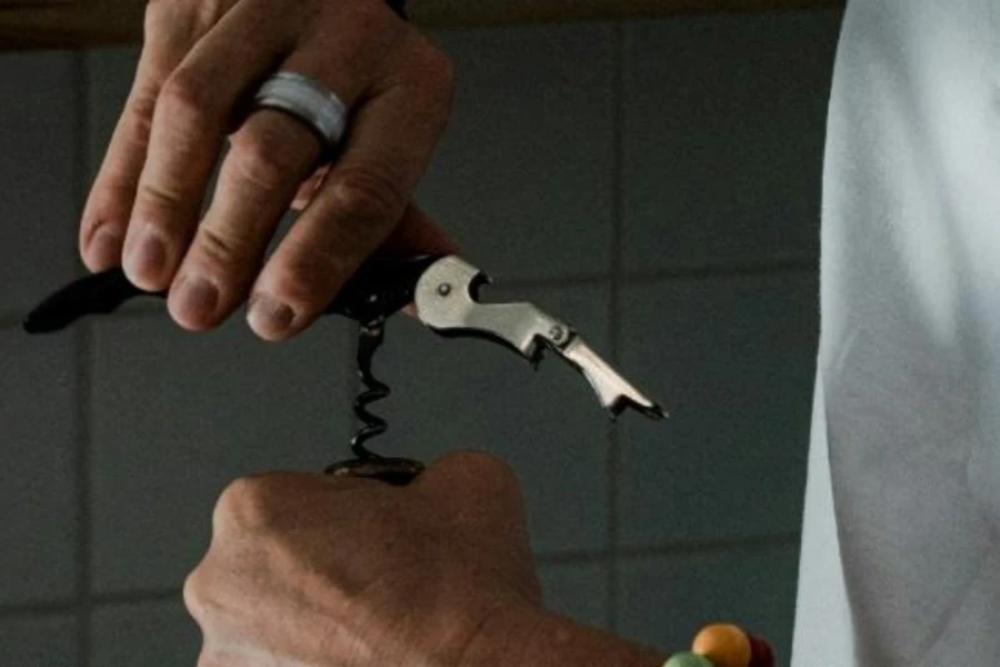 Person using corkscrew bottle opener