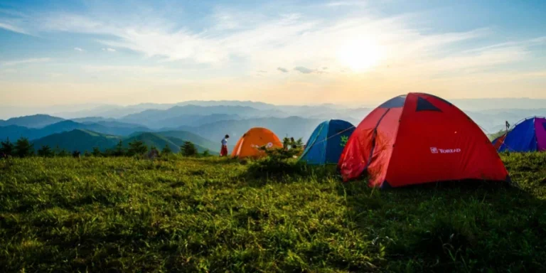 Fotografía de tiendas de campaña con cúpulas inclinadas con vistas a las cadenas montañosas