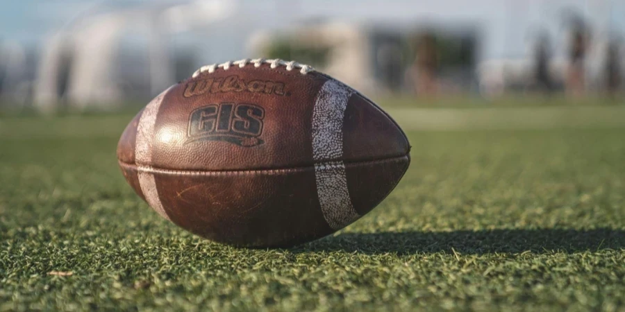 Selective Focus Close-up Photo of Brown Wilson Pigskin Football on Green Grass