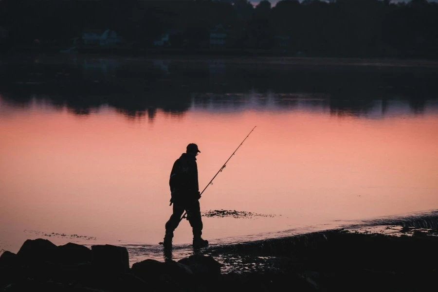 Silhouette of Fisherman on Lakeshore at Dawn