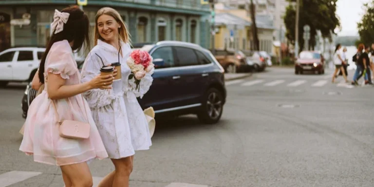 Chicas sonrientes con disfraces caminando por la calle