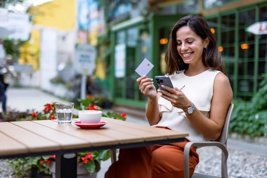 Smiling woman shopping online with her card